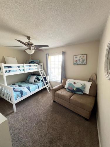a bedroom with a bunk bed and a couch at La SeaEsta in Navarre