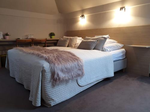 ein Schlafzimmer mit einem großen weißen Bett und einer flauschigen Decke in der Unterkunft BI&BI in Budapest