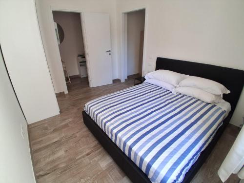 a bedroom with a bed with blue and white stripes at Bilocale nuovissimo! A due passi dal mare! in Levanto
