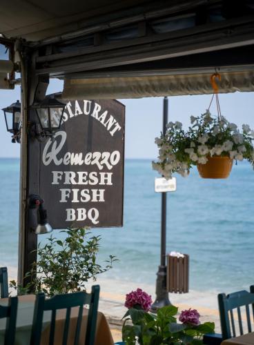 a sign for a seafood restaurant on the beach at Remezzo Guesthouse in Agios Ioannis Pelio