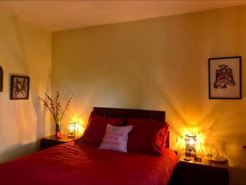 a bedroom with a red bed with two lamps at Villa Aux Chênaies in Obernai