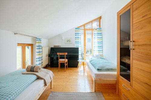a bedroom with two beds and a desk at Ferienwohnung Chiemgau in Eggstätt