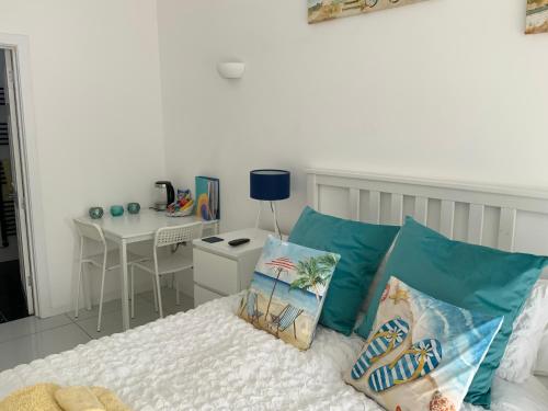 a bedroom with a bed with blue pillows and a desk at Double Bedroom with Private Entrance in Weymouth