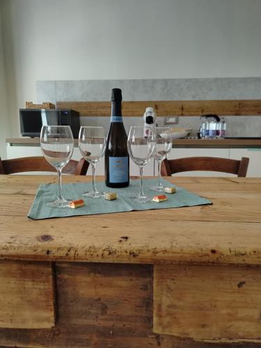 a table with four wine glasses and a bottle of wine at La Casa dei Ricordi in Igne