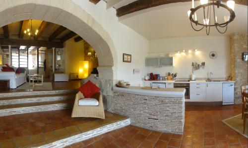 a kitchen and living room with a brick fireplace at Les Terraces Sur La Dordogne in Sainte-Foy-la-Grande