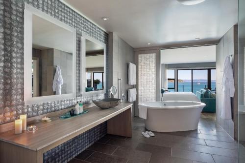 a bathroom with a tub and a large mirror at The Inn Above Tide in Sausalito