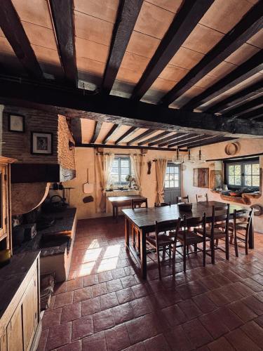 a kitchen and dining room with a table and chairs at Maison Le Grand Saule in Bugnein