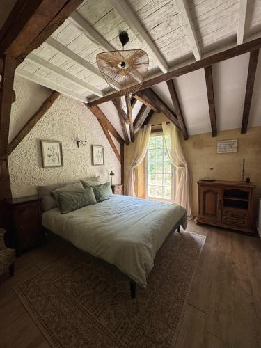 a bedroom with a large bed with a ceiling at Maison Le Grand Saule in Bugnein
