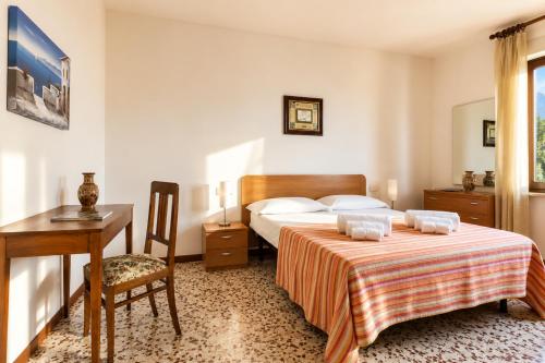 a hotel room with a bed and a desk and a table at Apartment Alex 1 in Domaso in Domaso