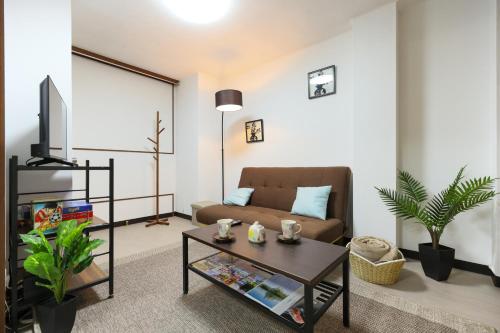 a living room with a couch and a coffee table at Desroches House in Kanazawa