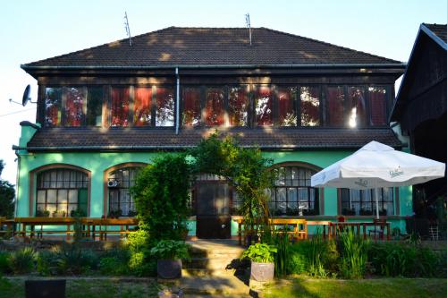a green building with an umbrella in front of it at Čarda Ranč in Berava