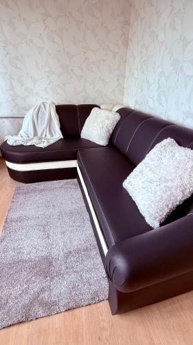 a black couch in a room with a rug at Uuemõisa apart in Haapsalu