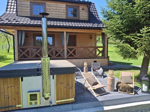 a log cabin with a stove and some chairs at Exclusive Forest House - Spiska Leśna Przystań in Łapsze Niżne