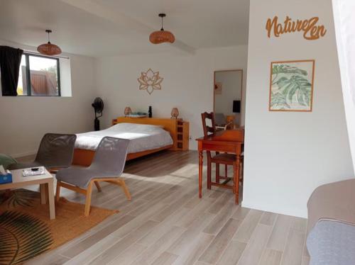a bedroom with a bed and a table and a desk at La Picardière in Perdreauville