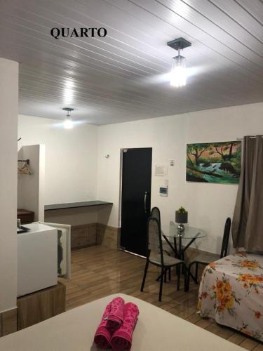 a room with a bed and a table with pink slippers at Pousada Aruanã in Soure