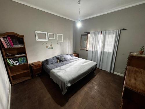 a bedroom with a bed and a book shelf at Dambofamily in Necochea