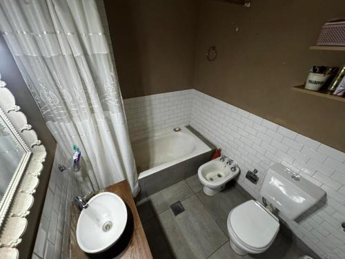 a bathroom with a sink and a toilet and a tub at Dambofamily in Necochea