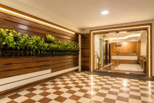 a lobby with a checkered floor and a wall with plants at Hotel Comfort Park - Opposite Sri Ramachandra Medical College Porur in Chennai