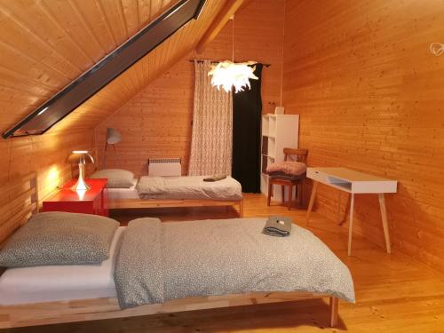 a attic room with two beds and a window at Pauza Drzewoszewo - Dom nad jeziorem in Drzewoszewo