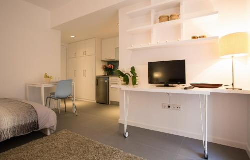 a bedroom with a white desk with a television on it at Homz Studios Faliro in Athens