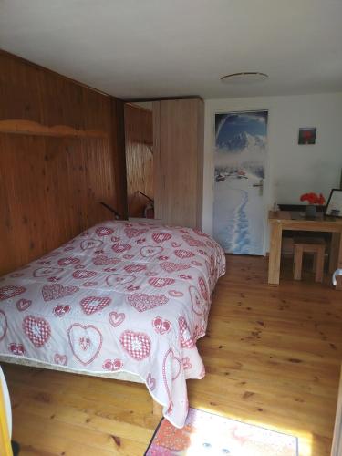 a bedroom with a bed with a pink bedspread at Le coquelicot -Draps inclus in Val Cenis