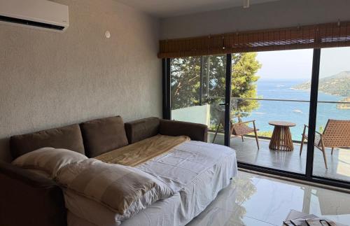 a living room with a couch and a view of the ocean at Mavinin ve Yeşilin dansı, Panoramik manzara, 75m2 in Marmaris