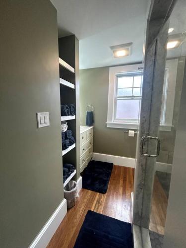 a bathroom with a shower and blue rugs at Steps to Derby Wharf and Gables. in Salem