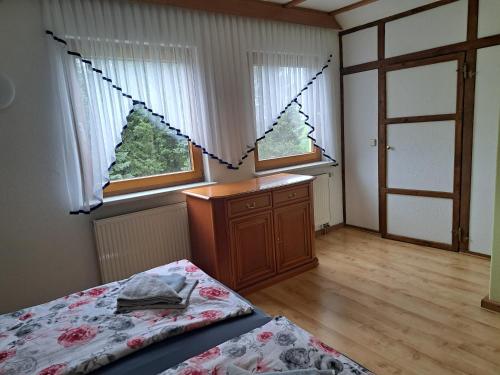 a bedroom with a bed and two windows at Blick zum See in Laasow