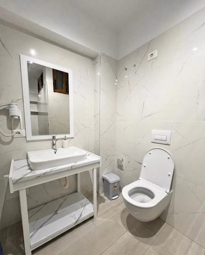 a white bathroom with a toilet and a sink at Floor Villa 2 in Vlorë