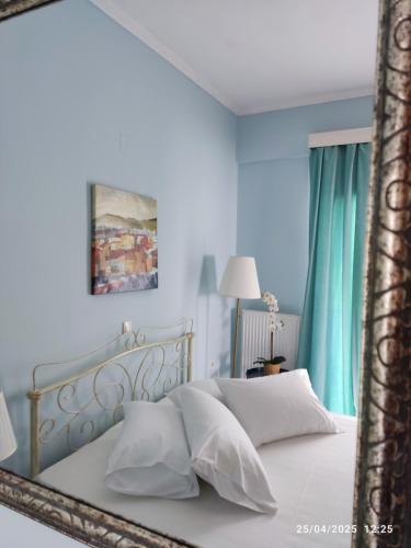 una camera da letto con un letto bianco con uno specchio di Morfi a Città di Lefkada