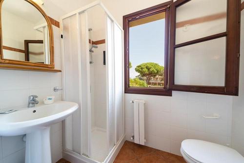 a white bathroom with a sink and a window at Hotel Voce del Mare in Capoliveri