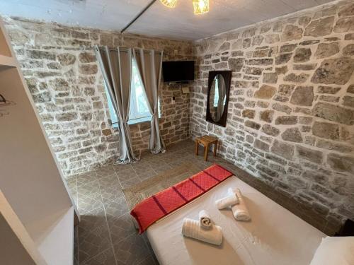 a bath tub in a room with a stone wall at Casa Rapata in Gaios