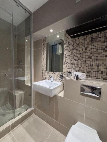 ein Badezimmer mit Waschbecken und Dusche in der Unterkunft Urbanight Boutique Hotel in Bloemfontein