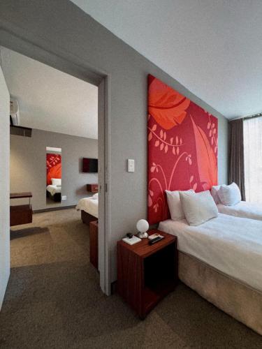 ein Hotelzimmer mit einem Bett und einem großen Fenster in der Unterkunft Urbanight Boutique Hotel in Bloemfontein