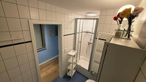 a bathroom with a shower and a vase of flowers at Strandperle in Timmendorfer Strand