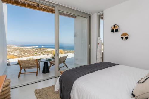a bedroom with a bed and a view of the ocean at THEIA VILLA in Adamantas