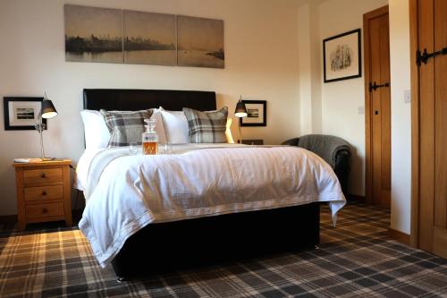 a bedroom with a large bed with white sheets and pillows at Modern, eco friendly house in Kildonan on Skye in Flashader