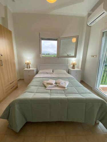 a bedroom with a large bed with two towels on it at Olyvia in Plaka Litochorou