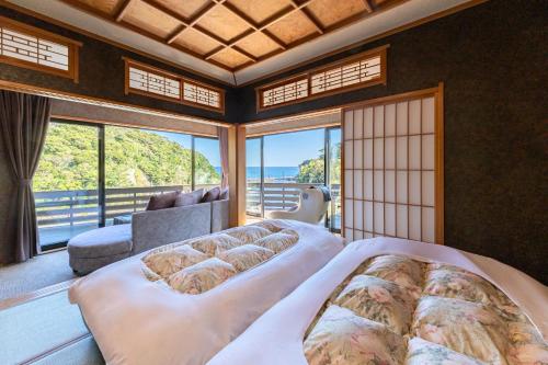 a bedroom with two beds in front of a window at 鵜原館 -Ubarakan- in Katsuura