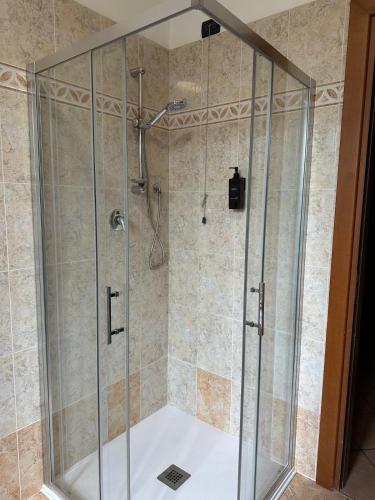a shower with a glass enclosure in a bathroom at Casa del Melograno Outlet in Serravalle Scrivia