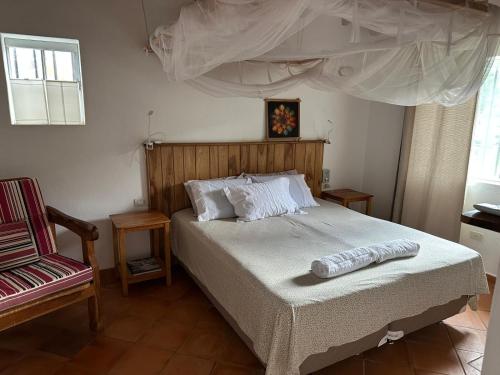 a bedroom with a bed and a chair at Casita de Piedra in Atyrá