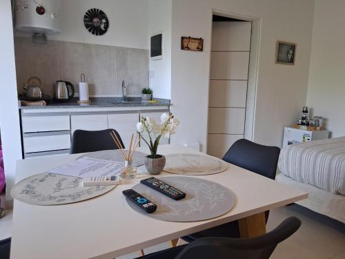 a dining room table with two remote controls on it at LENNON SUITE remis free Ezeiza in Ezeiza