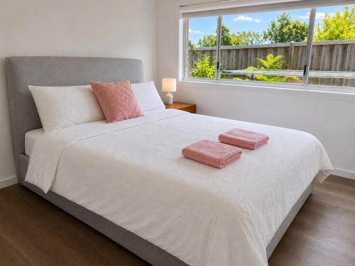 a bedroom with a large bed with two towels on it at 17 Pimpama Home in Pimpama