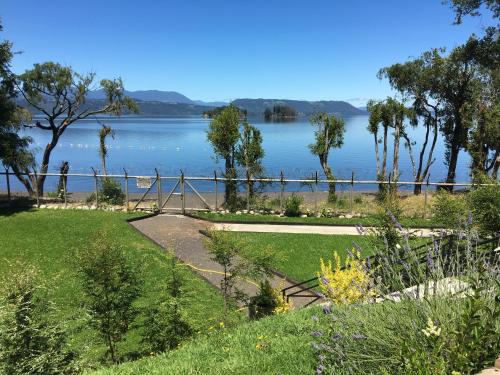a garden with a view of a lake at Cabañas El Roble Lican Ray in Licán Ray