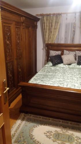 a bedroom with a bed with a wooden frame at Casa Bunicilor in Moldoviţa
