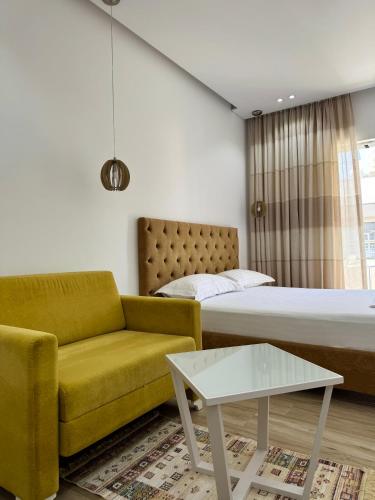 una camera da letto con un letto, un divano e un tavolo di Elena Hotel a Sarandë