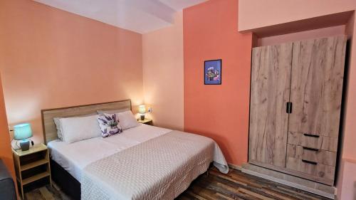 ein Schlafzimmer mit einem Bett und einer Holztür in der Unterkunft Уютно Централно Студио Враца in Vratsa