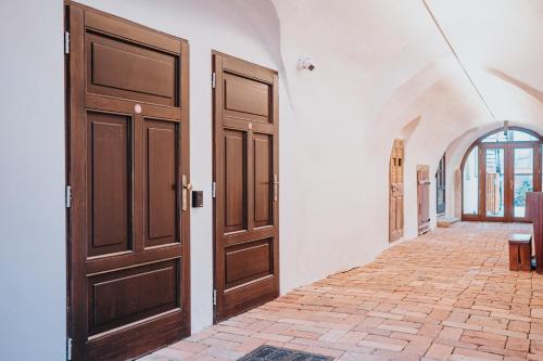 a hallway with two wooden doors in a building at genius loci apartments in Levoča