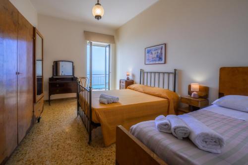 ein Hotelzimmer mit zwei Betten und einem Fernseher in der Unterkunft Palazzo Perez in Belvedere Marittimo