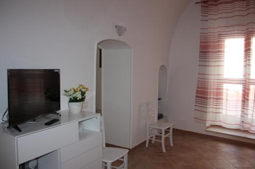 a living room with a flat screen tv on a dresser at Iaia Apartment in Sciacca